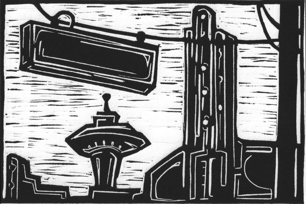 Black and white lincout print depciting the cross walk on queen anne ave with view of the spaceneedle in Seattle
